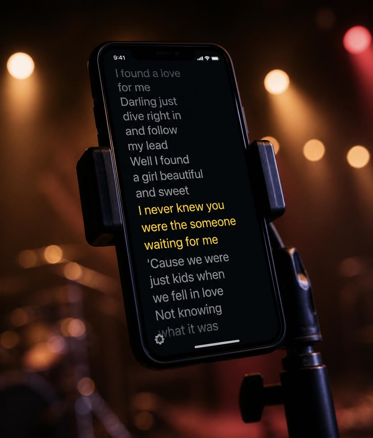 Smartphone montado no pedestal do microfone mostrando letra em teleprompter estilo karaokê